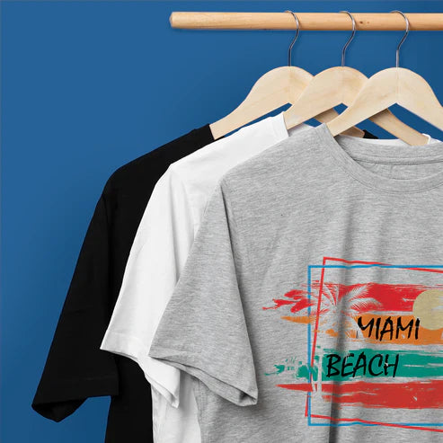 Custom DTF heat transfer applied on a gray t-shirt with a colorful Miami Beach design, displayed on a hanger with black and white t-shirts in the background