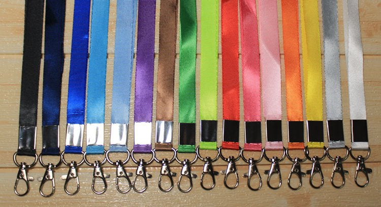 Custom nylon lanyards in multiple colors neatly aligned with metal lobster clips, perfect for ID holders, conferences, and corporate events