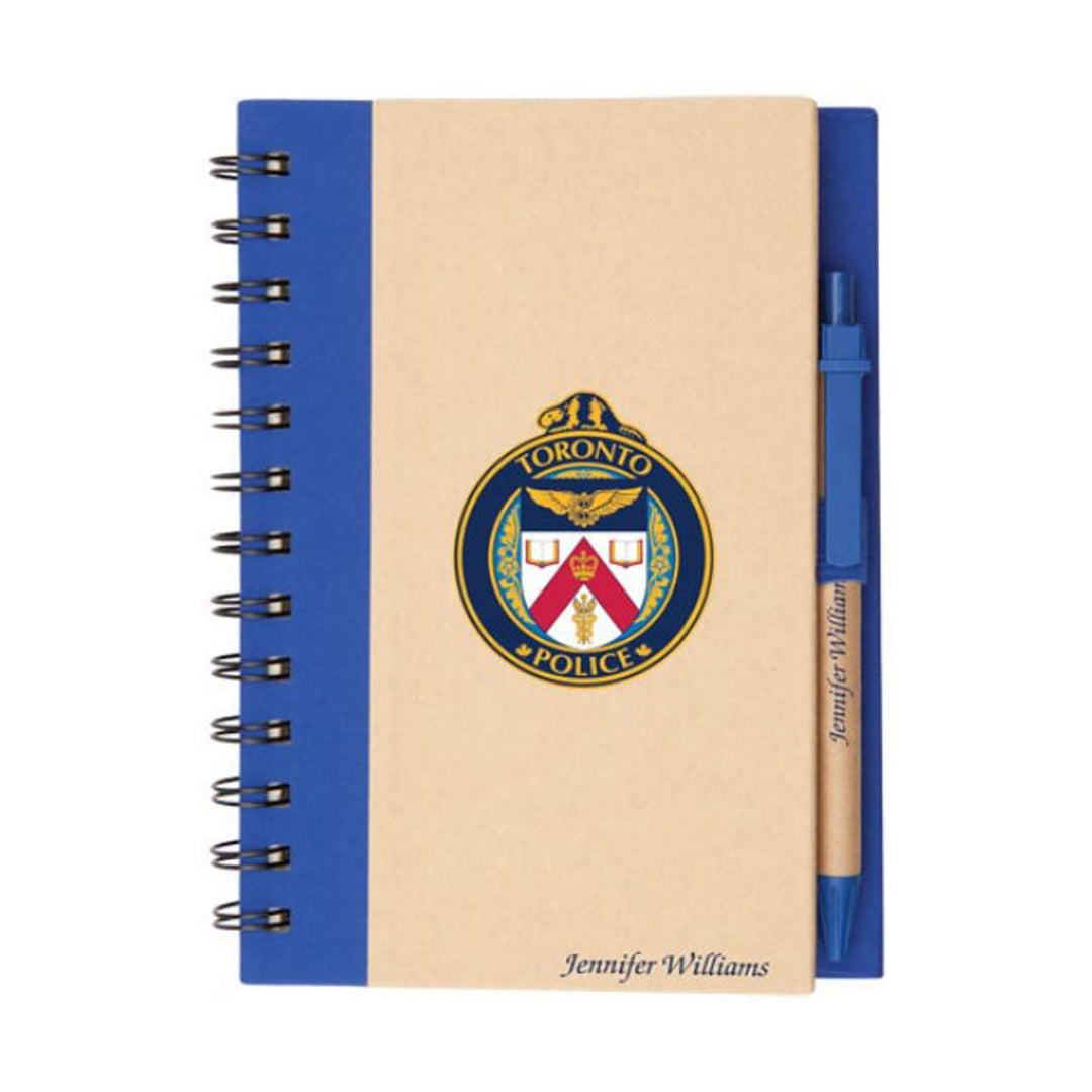 Spiral bound eco-friendly notebook with kraft cover, blue binding, and matching blue harvest pen, featuring Toronto Police logo and personalized name imprint.