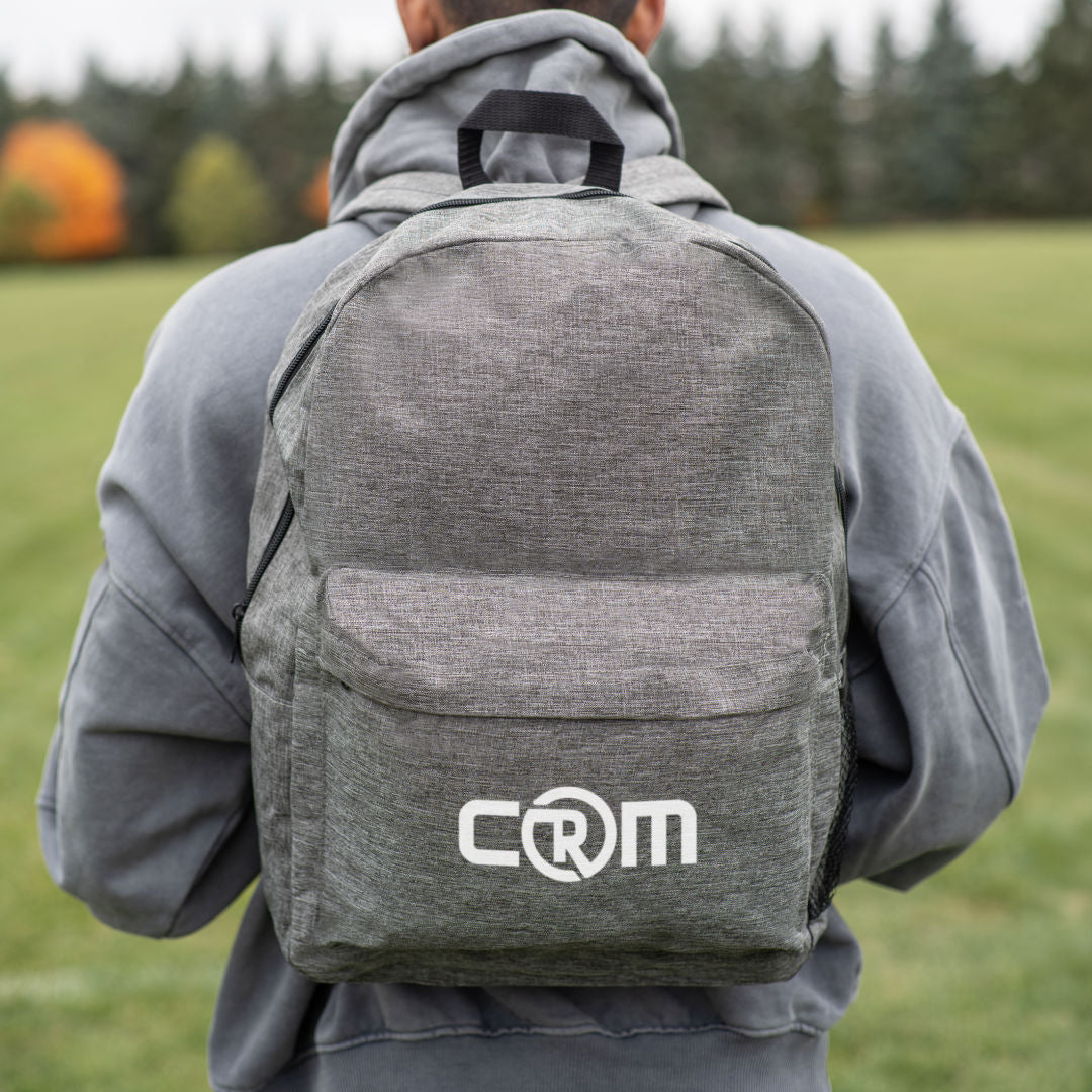 Tecumseh heather backpack 12"W x 7"D x 18"H in black with front zipper pocket, mesh side pocket, and custom CRM logo print