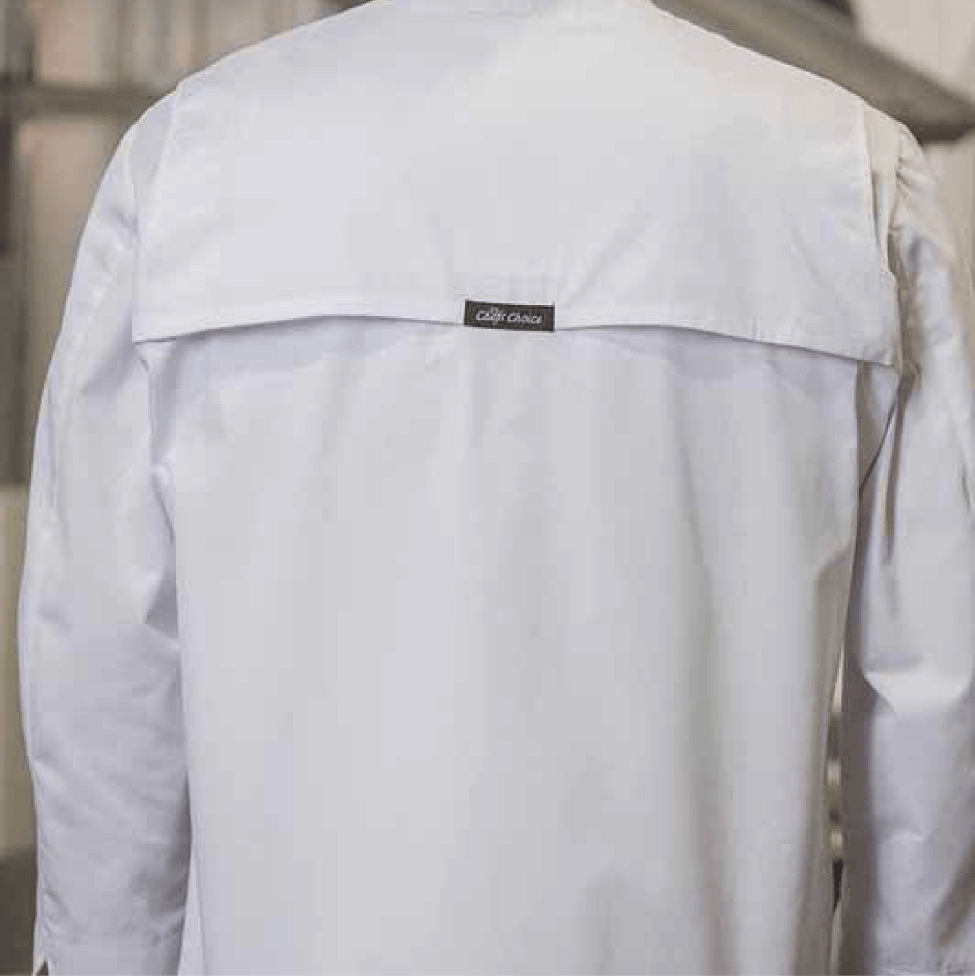 Back view of white chef coat with mesh yoke and Cafe Coats label