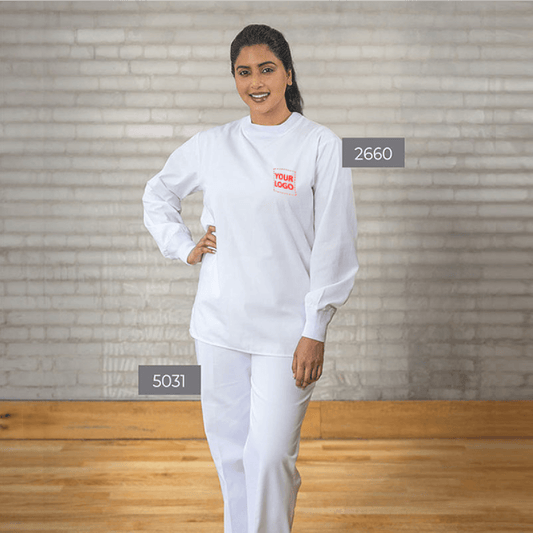 Woman wearing a white crew-neck scrub set with embroidered logo, featuring long sleeves and straight-leg pants