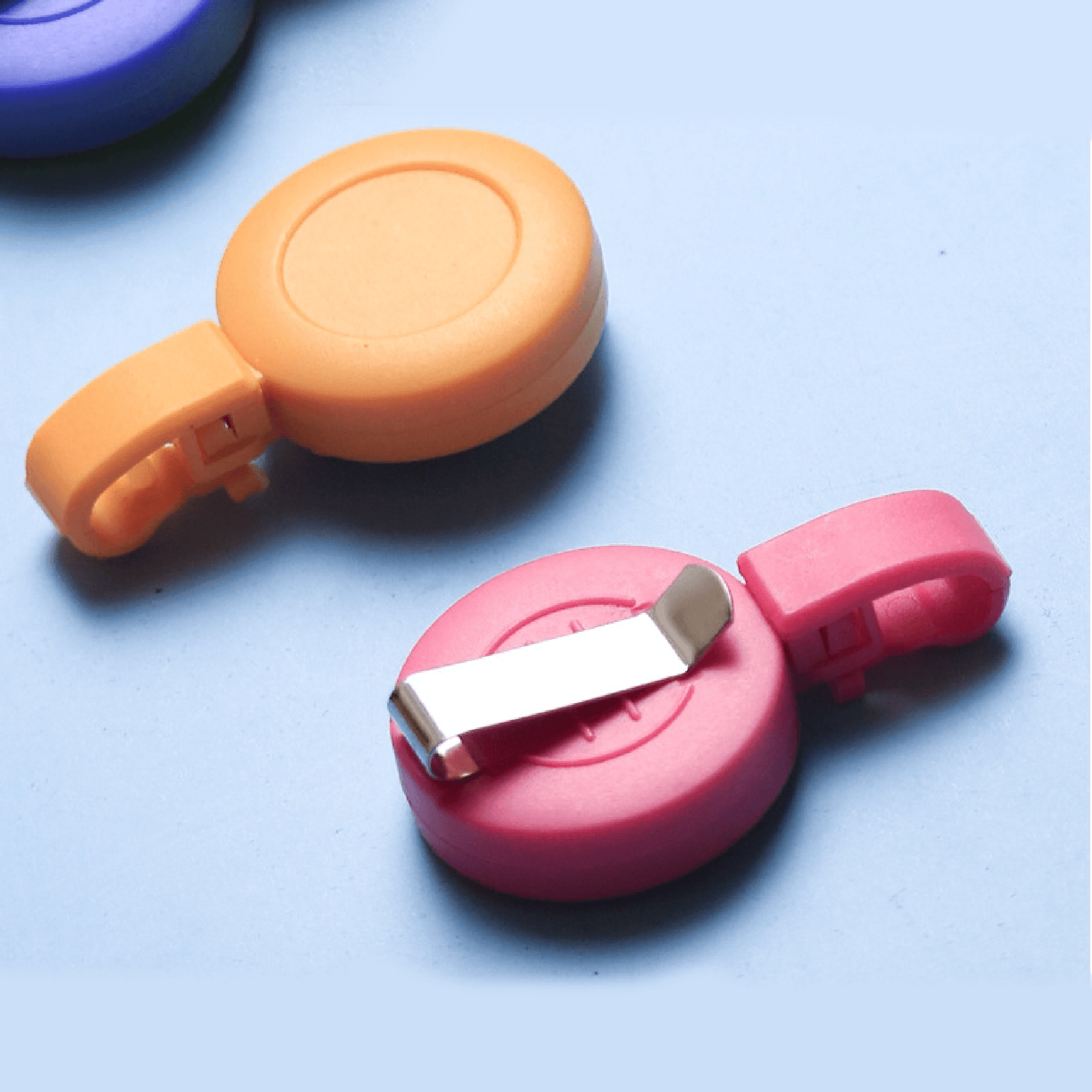 Custom logo printed colorful plastic badge reels with metal clip and retractable cord on blue background