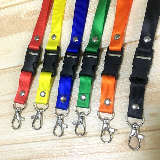 Custom print nylon lanyards in assorted colors with detachable buckle and metal lobster clips on wooden background