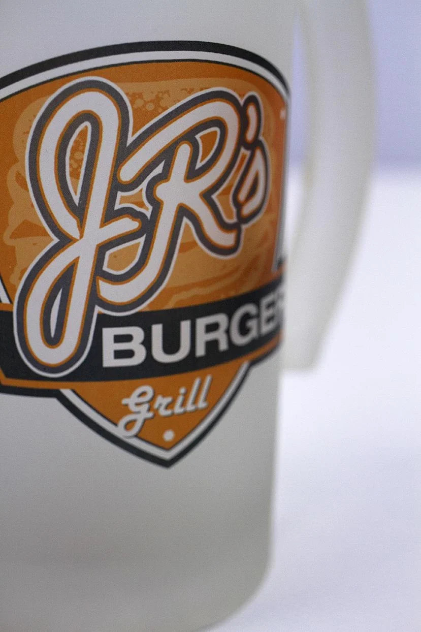Close-up of frosted beer stein featuring a full colour JR's Burger Grill logo in orange, black, and white.